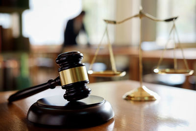 Close-up of gavel and weight scale on table