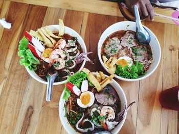 High angle view of food served in bowls on wooden table