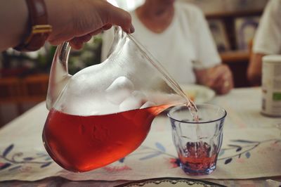 Close-up of hand pouring drink in glass