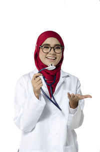 Portrait of teenage girl wearing mask against white background