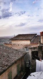 Houses in town against cloudy sky