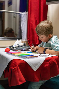 Boy drawing on paper at train