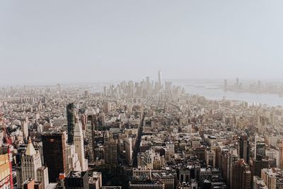 Aerial view of buildings in city against clear sky