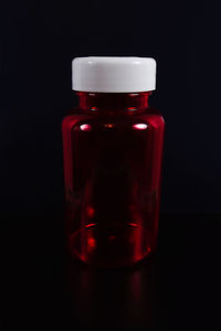 Close-up of red wine glass on table against black background