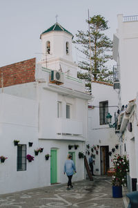 Rear view of woman walking on white building