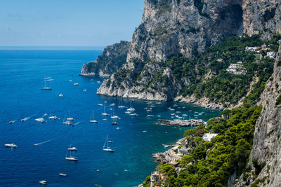 View of boats moored in calm blue sea