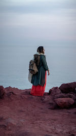 Rear view of woman looking at sea against sky