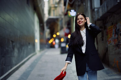 Portrait of young woman standing in city