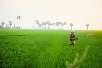Rear view of man on field against sky