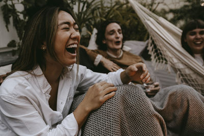 Smiling young woman sitting outdoors