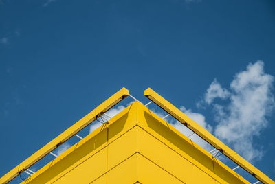 Low angle view of yellow built structure against blue sky