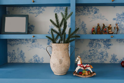 Christmas decor of a cozy home. spruce branches in a vase and a souvenir horse