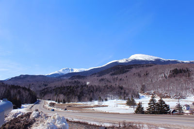 Scenic view of snowcapped mountains against blue sky