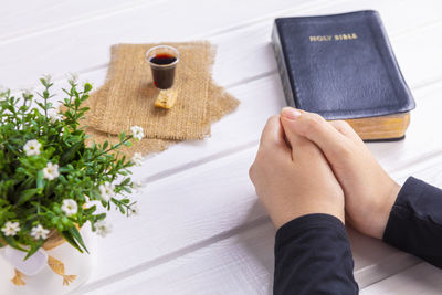 High angle view of hand holding book on table