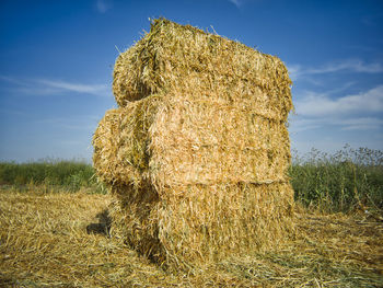 Hay bales on field against sky