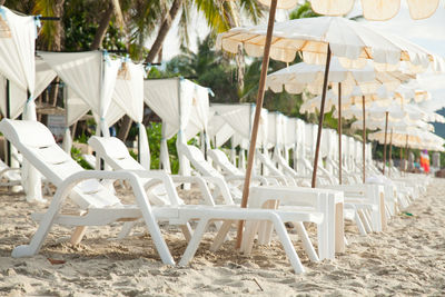 Empty lounge chairs and tables at beach