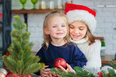 Two sisters playing in christmas kitchen with new years decor