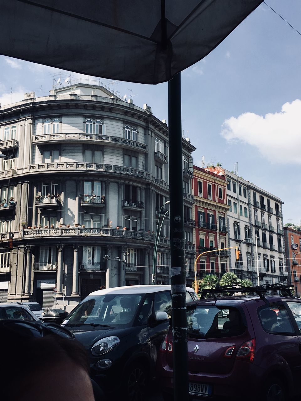 CARS ON ROAD BY BUILDINGS IN CITY