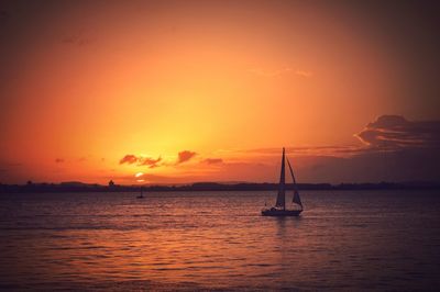 Boats in sea at sunset