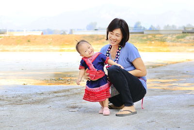 Mother and daughter on land against clear sky