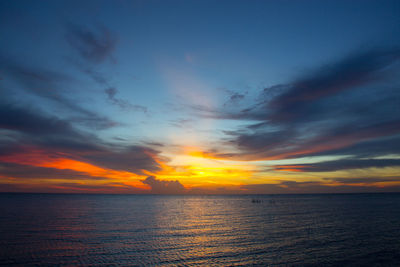 Scenic view of sea against dramatic sky during sunset