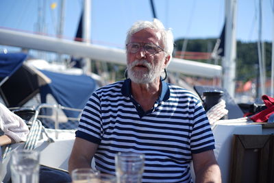 Senior man looking away while sitting in boat