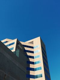 Low angle view of office building against blue sky