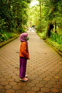 Rear view of hijab girl walking on footpath