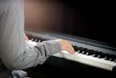 Cropped image of woman playing piano