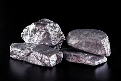 Close-up of stones on rock against black background