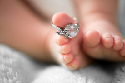 Close-up of baby foot with ring on floor