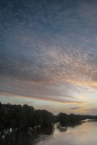 Scenic view of lake against sky at sunset