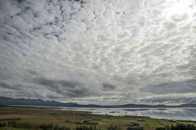 View of calm lake against cloudy sky