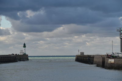 Lighthouse by sea against sky