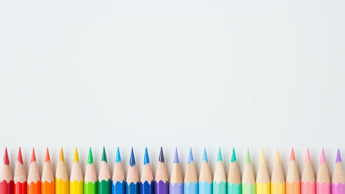 Close-up of colored pencils against white background