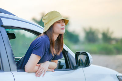 Woman wearing hat while sitting in car