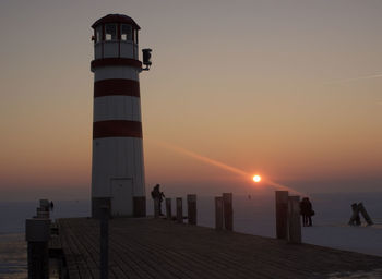 Lighthouse at seaside during sunset