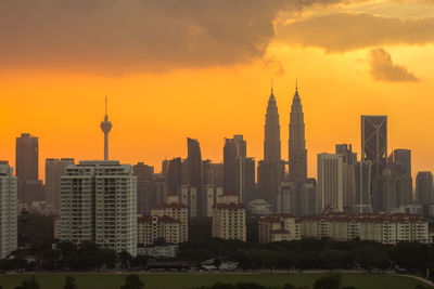 Skyscrapers in city against cloudy sky