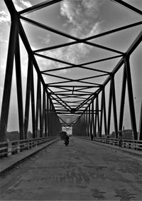 Rear view of man walking on footbridge