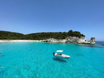 Sailboat in sea against clear blue sky