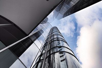 Low angle view of modern building against cloudy sky