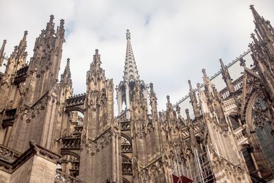 Low angle view of cologne cathedral against cloudy sky