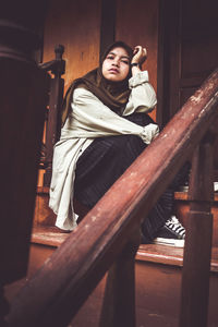 Portrait of woman sitting on staircase