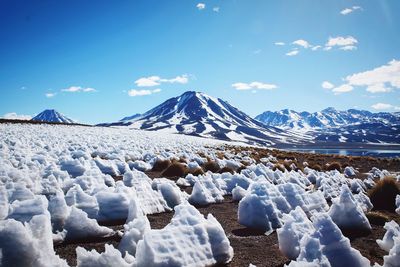 Scenic view of snowcapped mountains against blue sky