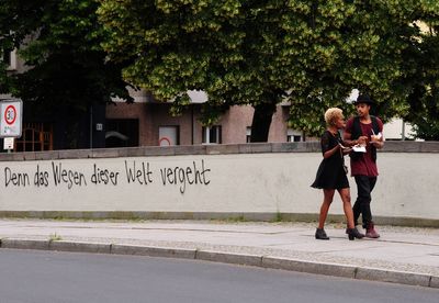 Full length of woman walking with text against trees