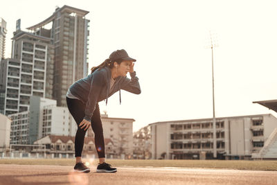 Full length of woman standing on field against building