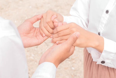 Midsection of couple holding hands