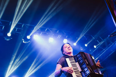 Low angle view of woman playing at music concert