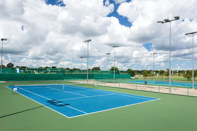 Empty tennis court against cloudy sky