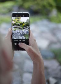 Midsection of woman photographing through mobile phone